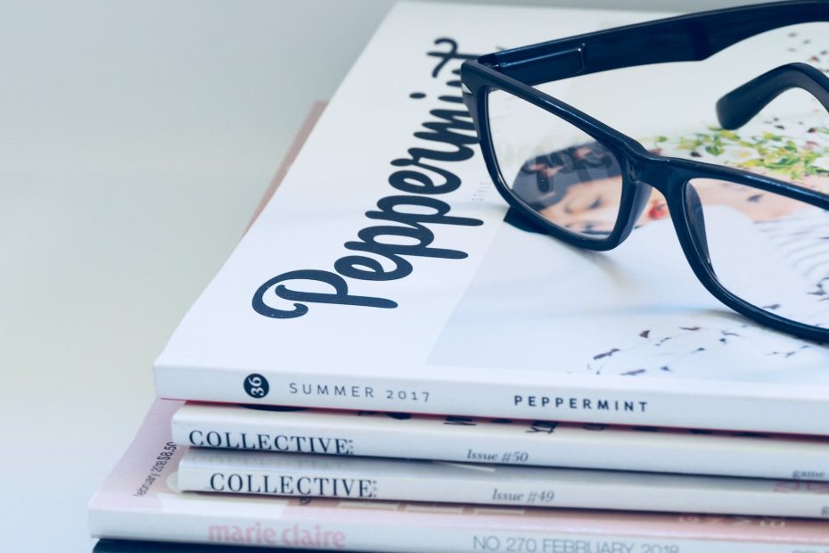 photo of eyeglasses on top of magazines