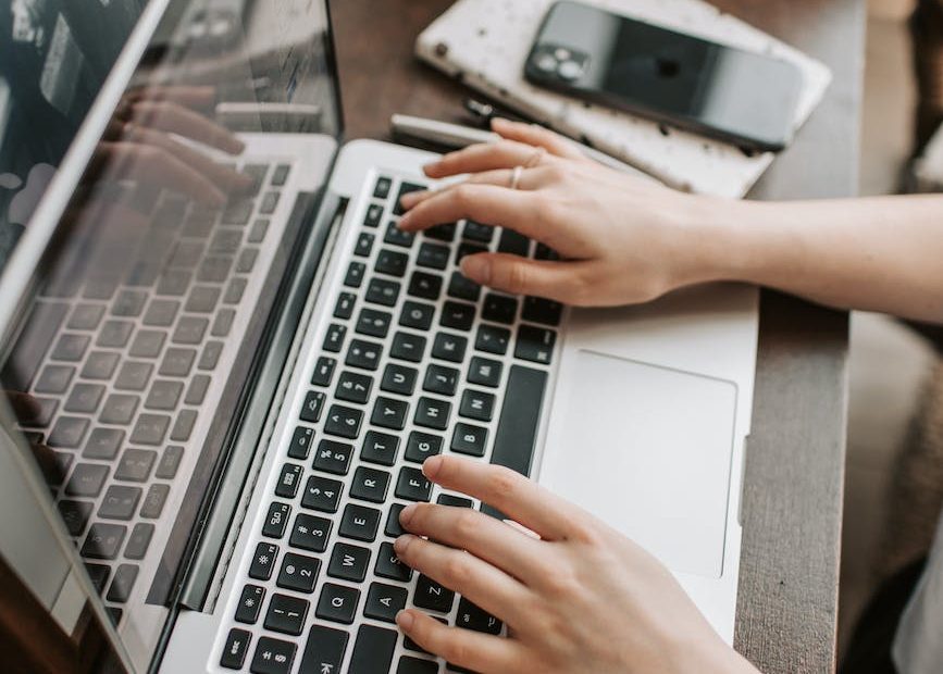 crop female freelancer using laptop at table at home