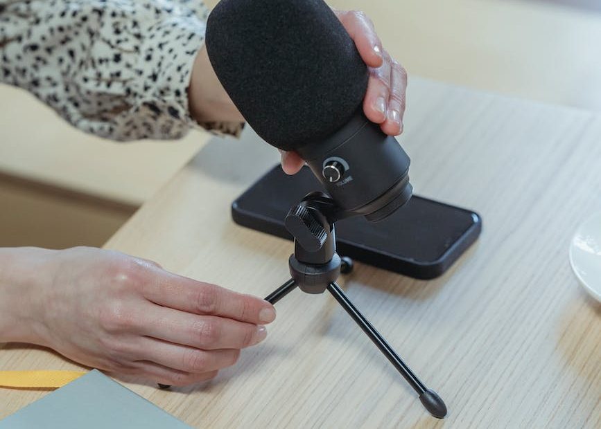 anonymous woman putting microphone on table before conference in office